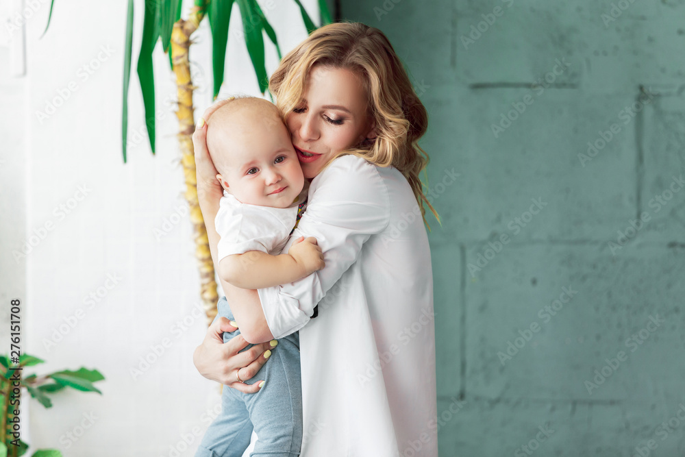 Charming young mother soothes her sad crying baby. A little baby cries