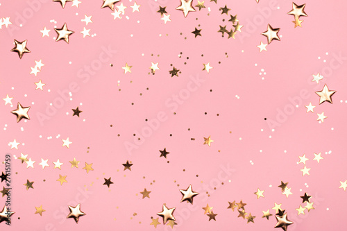 Golden stars glitter on pink background. Festive holiday pastel backdrop.