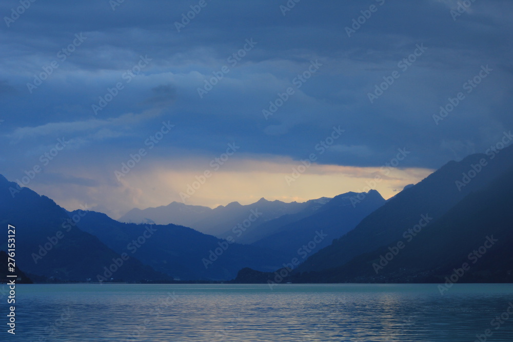 Summer scene at Lake Brienz. Last sunlight of the day and thunderstorm over Interlaken, Switzerland.