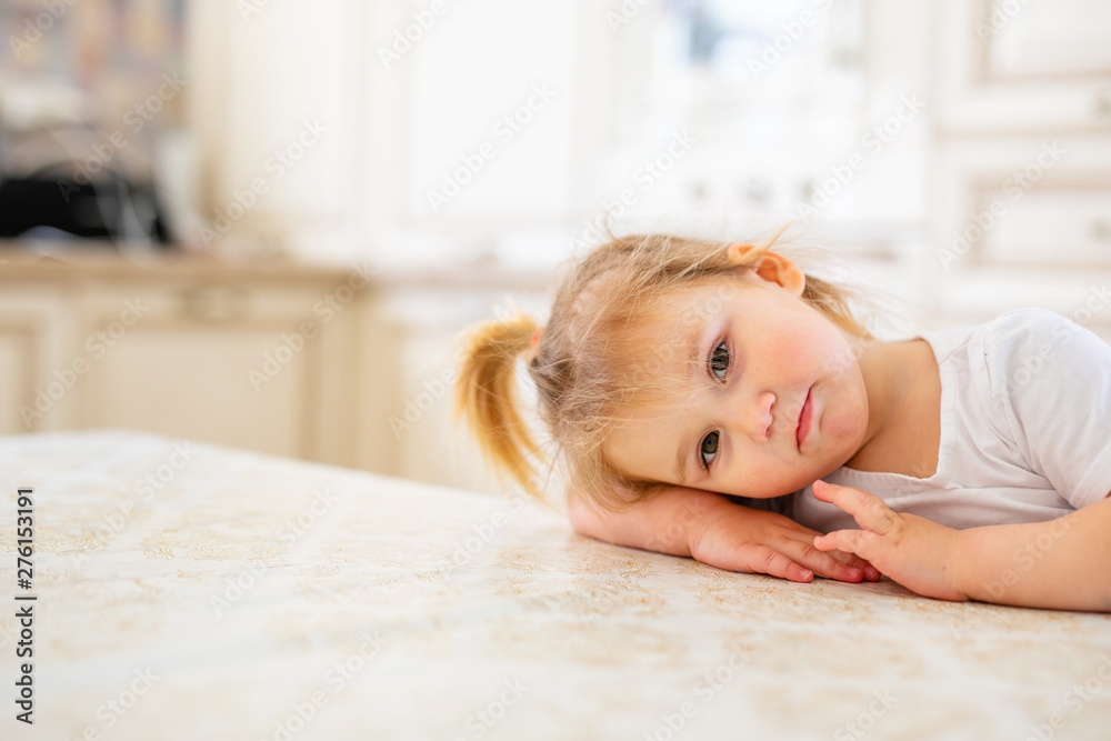 Adorable baby girl in white sunny bedroom. Newborn child relaxing on a blue bed. Nursery for young children. Newborn kid during tummy time with toys at a window Adorable baby girl in white sunny bedroom. Newborn child relaxing on a blue bed. Nursery for young children. Newborn kid during tummy time with toys at a window