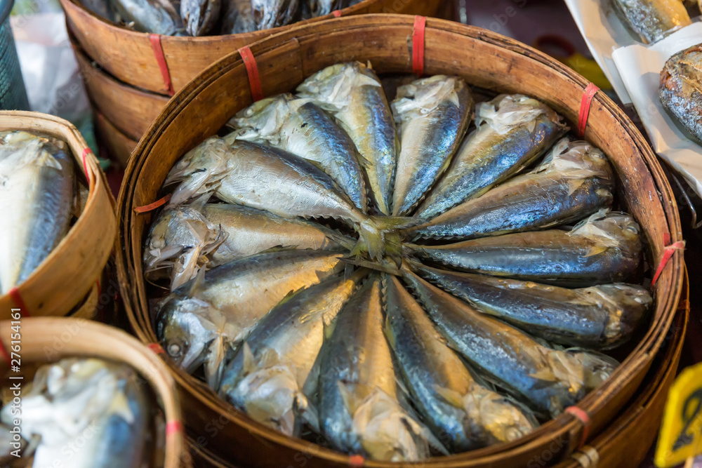 Steamed mackerel sold in the market. Thai steamed mackerel fishes in bamboo basket for sale at the market. Basket of steamed mackerel for sell at the local market .