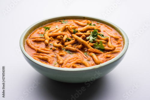 Dhaba style Sev bhaji/sabzi/curry made in tomato curry with gathiya shev, served in a bowl or karahi, selective focus photo