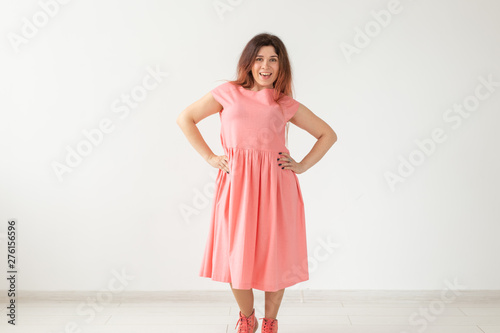 people, fashion and design concept - young woman posing in rose dress on white background with copy space