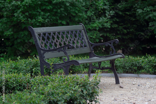 Metal bench in palace park on green background