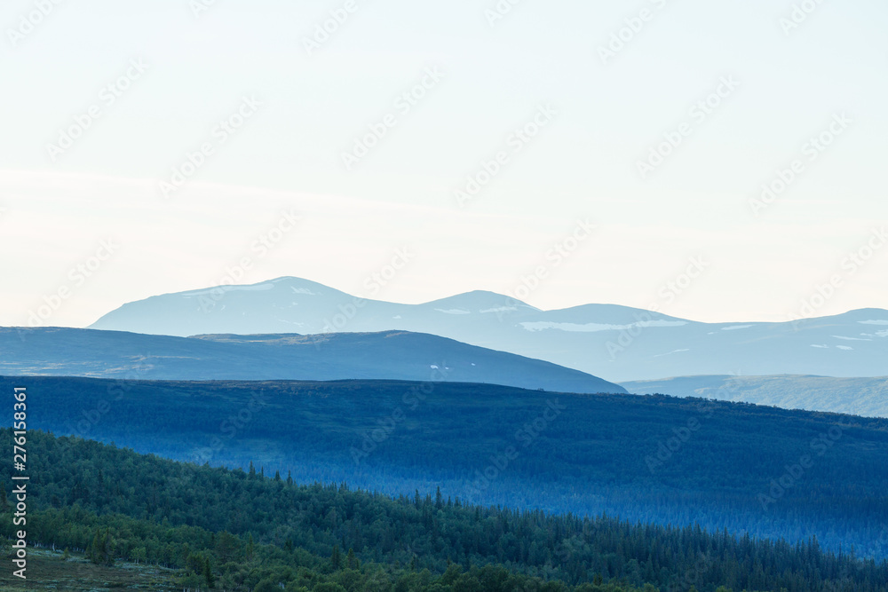 Forest and mountain silhouettes in the evening light Forest and mountain silhouettes in the evening light