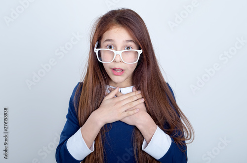 Portrait of a surprised red haired girl with glasses. School girl.