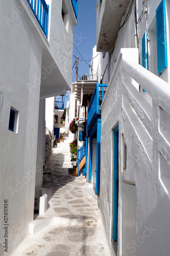 Fototapeta Naklejka Na Ścianę i Meble -  One of the charms of Mykonos, Greek island in the heart of the cyclades, are its narrow streets : white houses with small flowered balconies touching almost above paved streets