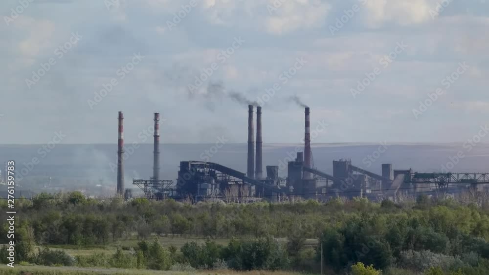 Smoking chimneys of a metallurgical plant in the summer Smoking chimneys of a metallurgical plant in the summer