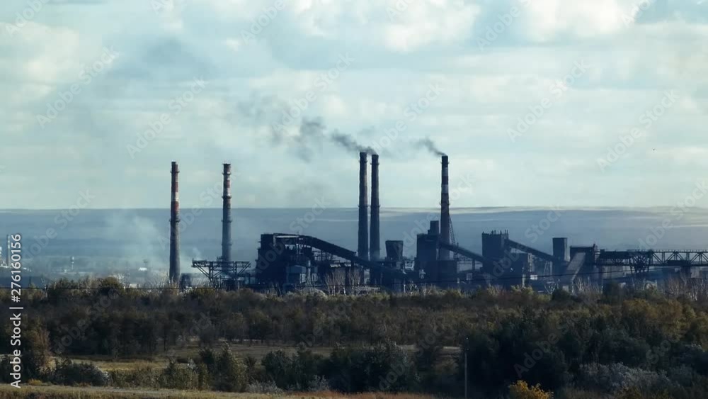 Smoking chimneys of a metallurgical plant in the summer Smoking chimneys of a metallurgical plant in the summer