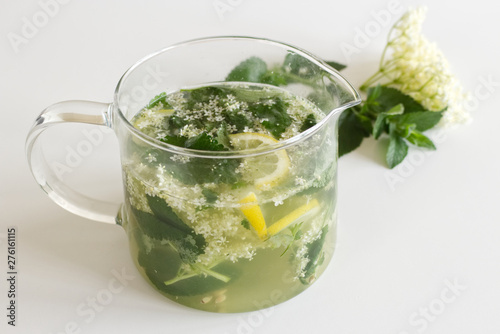 Homemade elderflower lemonade with lemon and elderflower on a wooden table. Summer cold and ,refreshing drink.