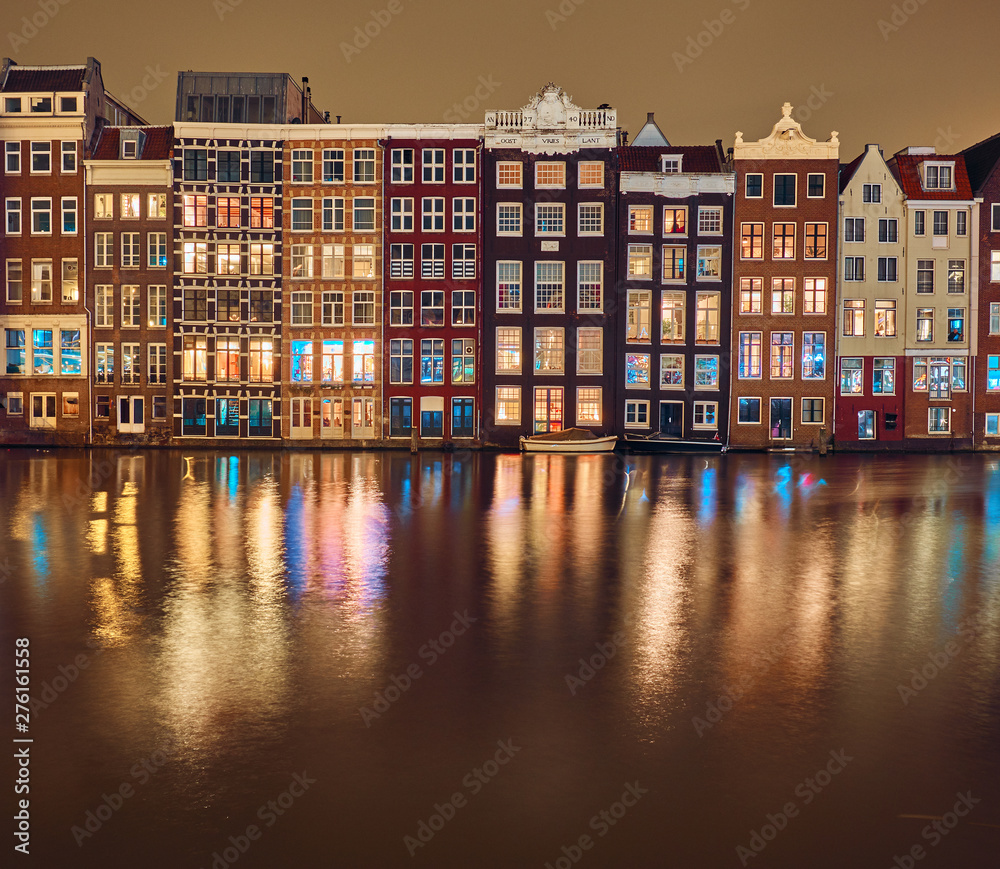 Brick houses and canal in amsterdam at night
