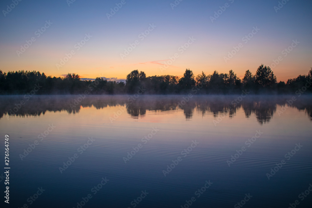 Sunset on the river. Forest reflection in water Sunset on the river. Forest reflection in water