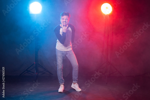 Jazz funk, dancing and hobby concept - young man dancing in spotlight