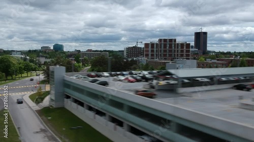 Drone hyper lapse coming down beside a parking garage in Carelton University beside the football field and parking lots. photo