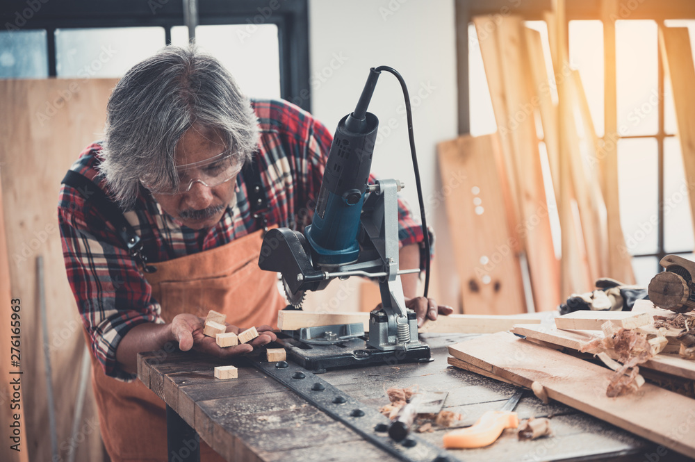 Carpenter working on woodworking machines in carpentry shop