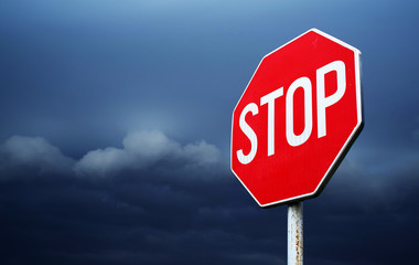Conceptual stop sign with stormy background. Warning, caution and danger sign