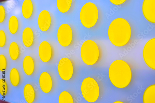 Vibrant yellow polka dot pattern on white background, selective focus perspective.