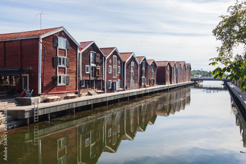 Old red wooden port warehouses next to the water in Hudiskvall historic center, Sweden Old red wooden port warehouses next to the water in Hudiskvall historic center, Sweden