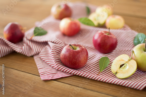 fruits, food and harvest concept - ripe red apples on wooden table