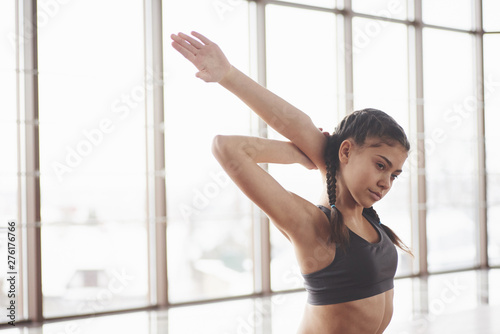 Conception of health care. Relaxed cute young girl sits on the floor in gym with big windows Free Download Conception of health care. Relaxed cute young girl sits on the floor in gym with big windows - GFXLoad
