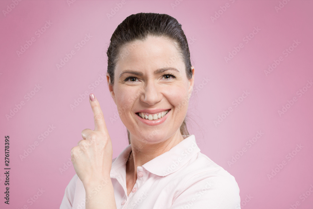 middle-aged woman shows emotional expressions in front of a pink background middle-aged woman shows emotional expressions in front of a pink background