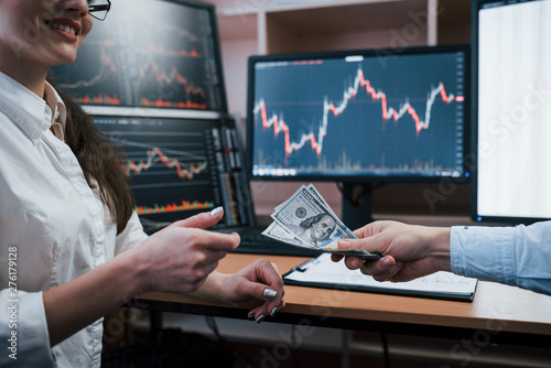 Here's your payday. Day of salary in the modern office with screens with graphs on them