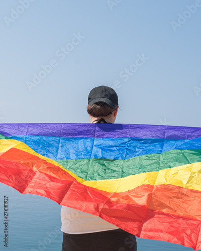 Young girl from behind  holding a banner looking at the sea