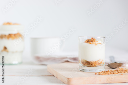 Healthy meal made of granola in glass, Yogurt and cornflakes Decorate food with Cashew Nut setting on white wooden table, healthy care concept, copy space
