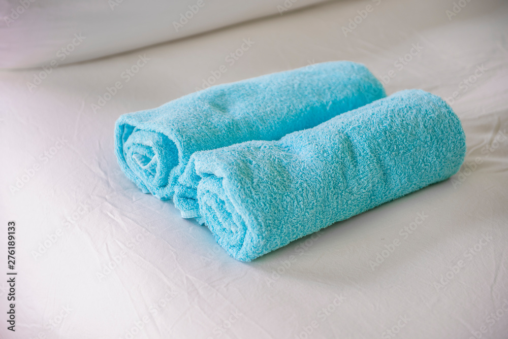 Blue towels on white bed