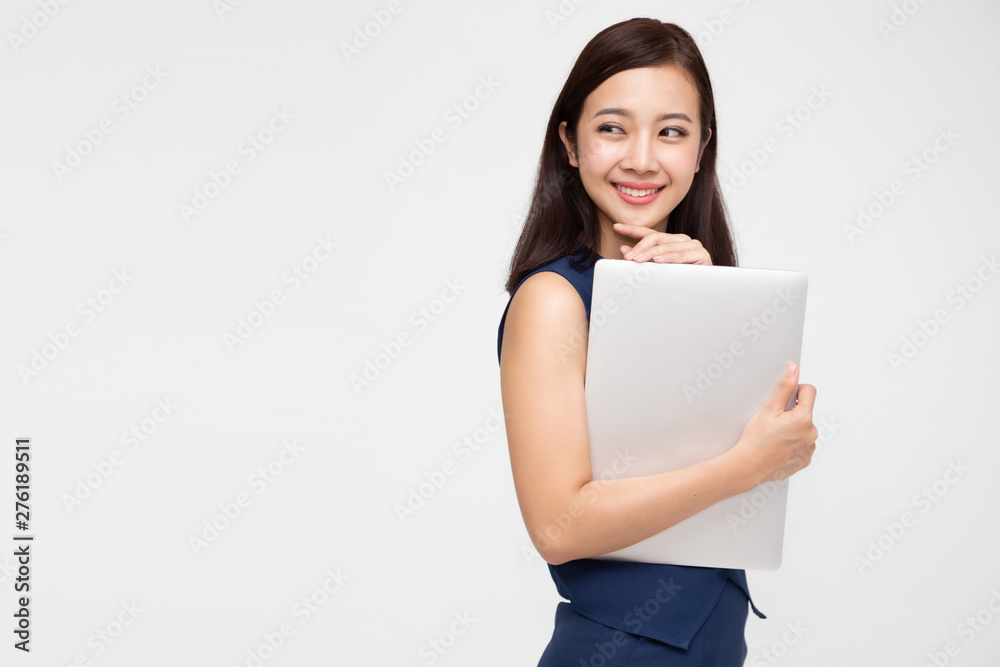 Happy Asian business woman holding laptop computer and looking away on white background Happy Asian business woman holding laptop computer and looking away on white background