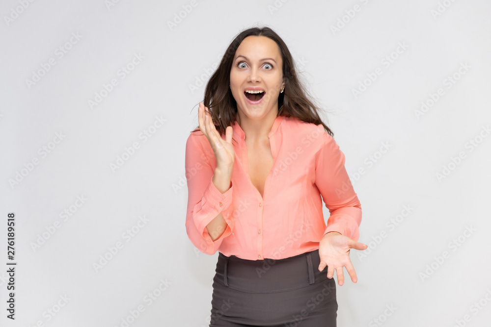Portrait to the waist a young pretty brunette manager woman of 30 years in business clothes with beautiful dark hair. Standing on a white background, talking, showing hands, with emotions. Portrait to the waist a young pretty brunette manager woman of 30 years in business clothes with beautiful dark hair. Standing on a white background, talking, showing hands, with emotions.