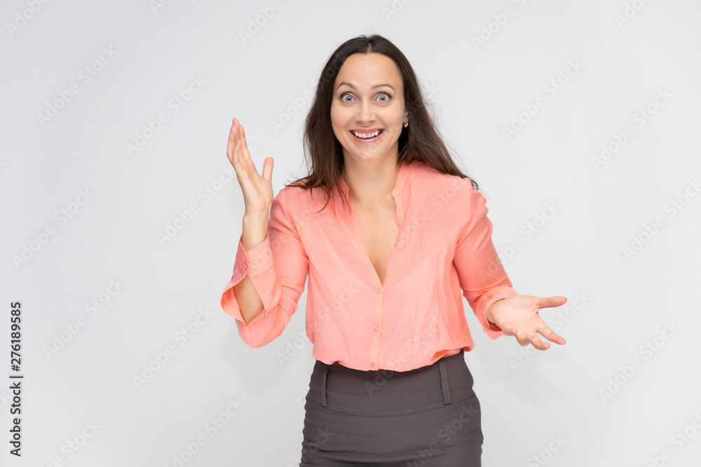Portrait to the waist a young pretty brunette manager woman of 30 years in business clothes with beautiful dark hair. Standing on a white background, talking, showing hands, with emotions. Portrait to the waist a young pretty brunette manager woman of 30 years in business clothes with beautiful dark hair. Standing on a white background, talking, showing hands, with emotions.