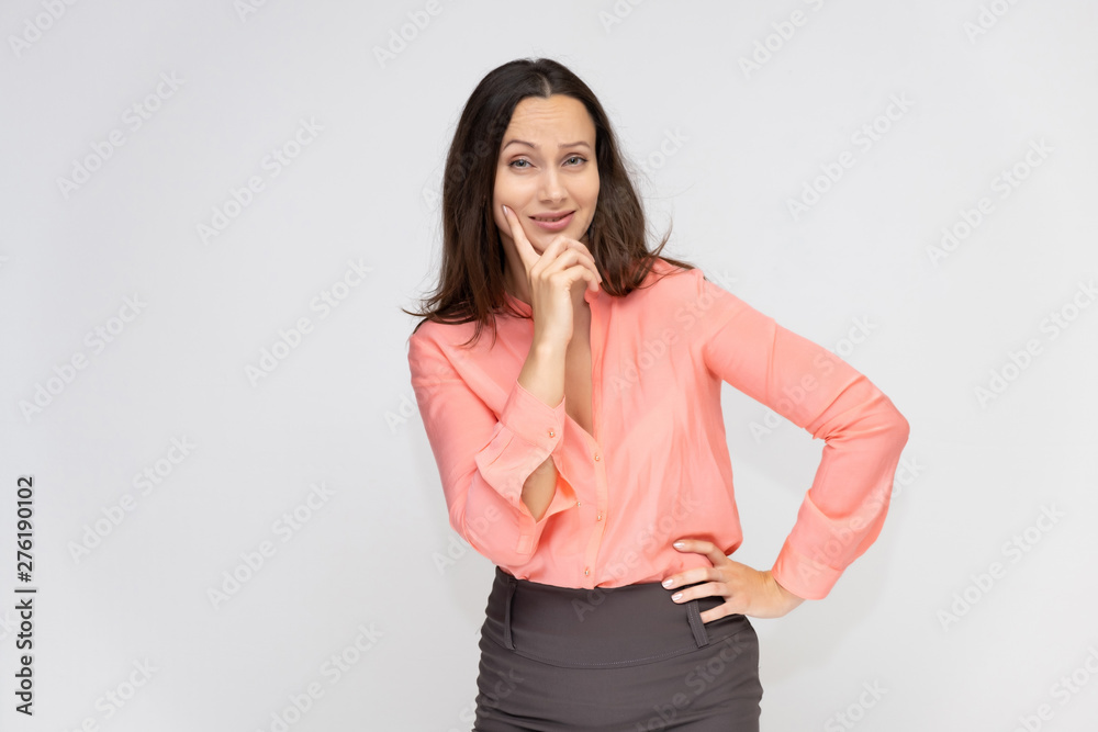 Portrait to the waist a young pretty brunette manager woman of 30 years in business clothes with beautiful dark hair. Standing on a white background, talking, showing hands, with emotions. Portrait to the waist a young pretty brunette manager woman of 30 years in business clothes with beautiful dark hair. Standing on a white background, talking, showing hands, with emotions.