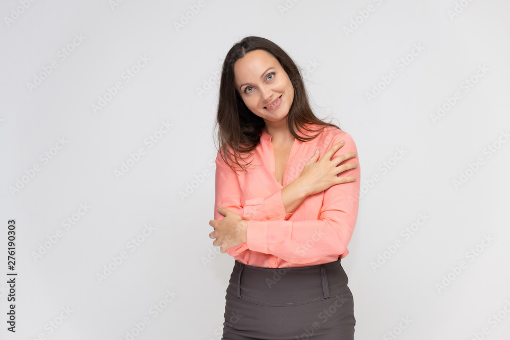 Portrait to the waist a young pretty brunette manager woman of 30 years in business clothes with beautiful dark hair. Standing on a white background, talking, showing hands, with emotions. Portrait to the waist a young pretty brunette manager woman of 30 years in business clothes with beautiful dark hair. Standing on a white background, talking, showing hands, with emotions.