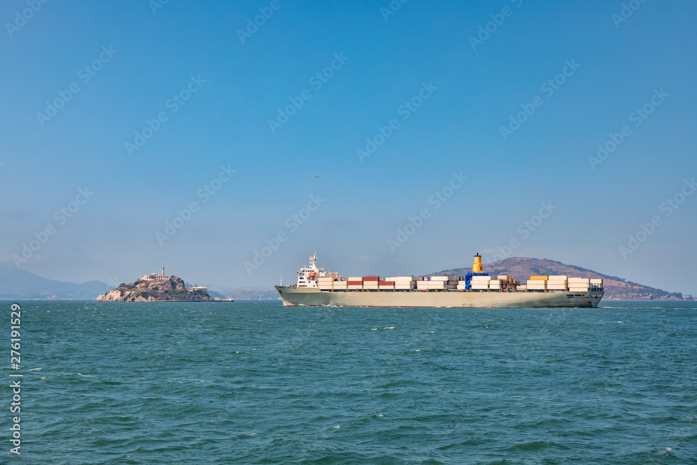 Container cargo ship close to Alcatraz island in San Francisco.
