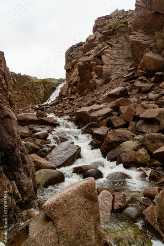 Stormy waters of the northern waterfall in a rocky gorge on the shores of the cold sea