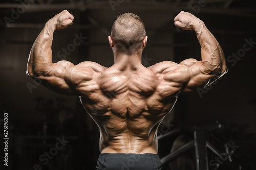 strong athletic men pumping up back muscles workout fitness