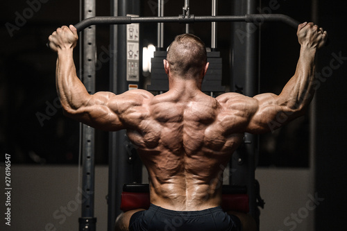 strong athletic men pumping up back muscles workout fitness
