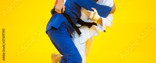 Two judo fighters in white and blue uniform. photo