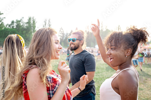 Group of friends having fun at summer music festival