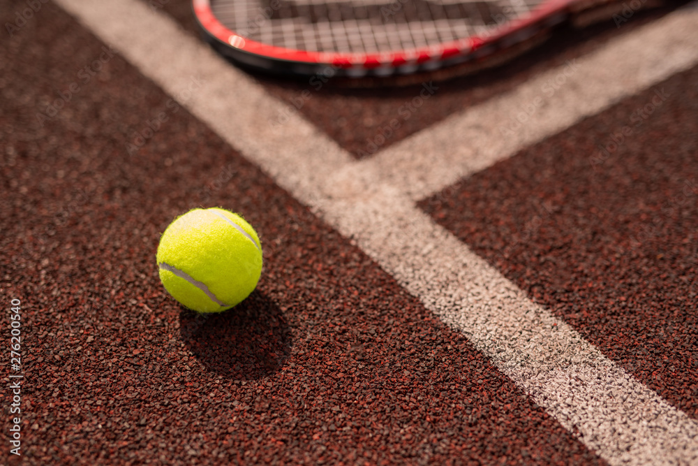 Yellow tennis ball by white line of sports playground