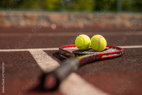 Two balls for playing tennis on racket crossing white line © pressmaster