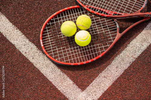 Top view of two tennis rackets and three yellow balls © pressmaster