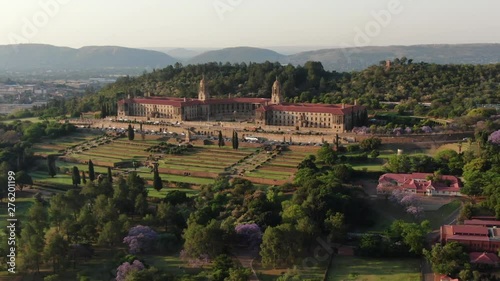 Aerial view of The Union Buildings, government offices in Pretoria, South Africa. Slowly pulling back revealing the beautiful, manicured gardens and some blooming Jacaranda trees.