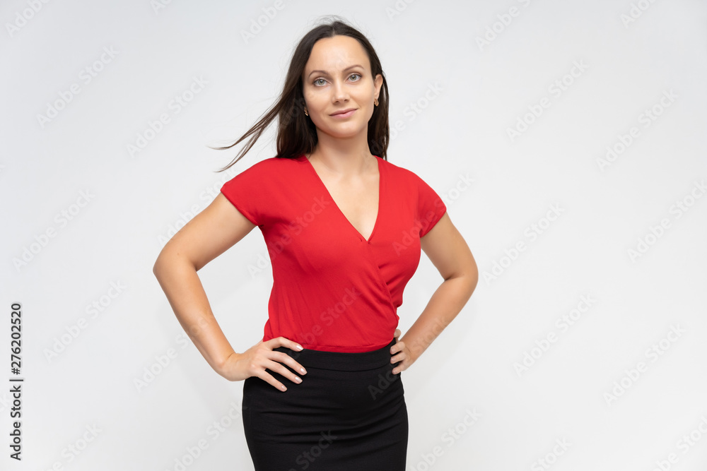 Portrait to the waist of a young pretty brunette woman of 30 years old in a bright red sweater with beautiful dark hair. Standing on a white background, talking, showing hands, with emotions Portrait to the waist of a young pretty brunette woman of 30 years old in a bright red sweater with beautiful dark hair. Standing on a white background, talking, showing hands, with emotions