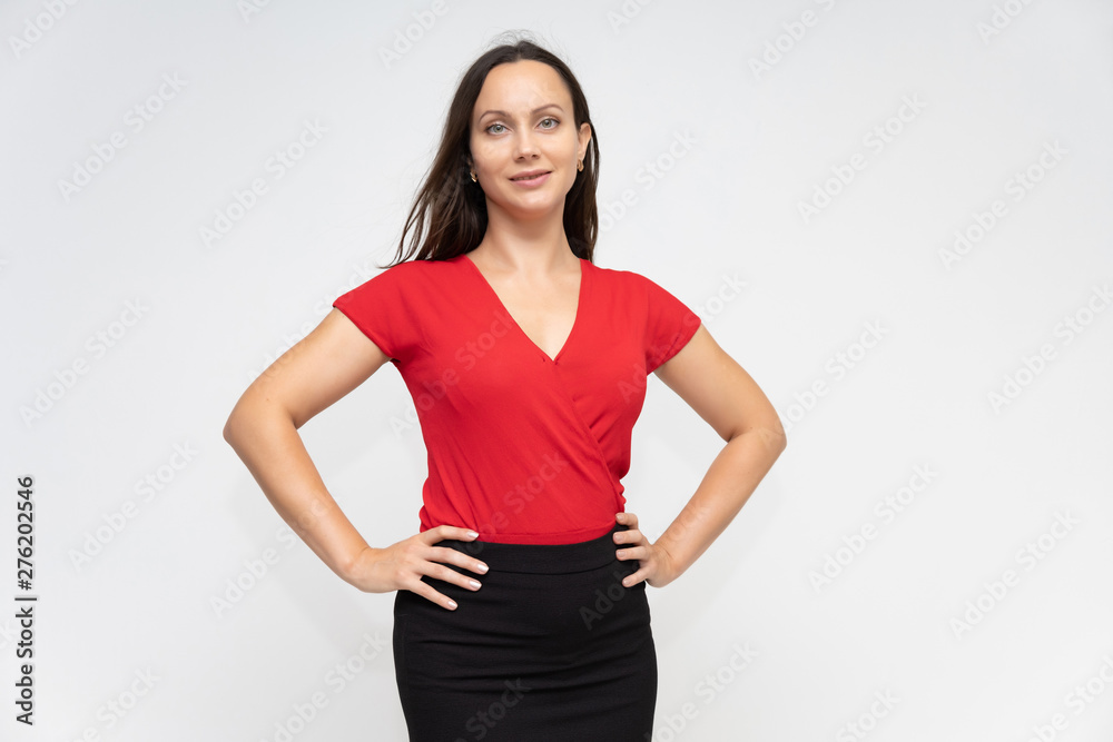 Portrait to the waist of a young pretty brunette woman of 30 years old in a bright red sweater with beautiful dark hair. Standing on a white background, talking, showing hands, with emotions Portrait to the waist of a young pretty brunette woman of 30 years old in a bright red sweater with beautiful dark hair. Standing on a white background, talking, showing hands, with emotions