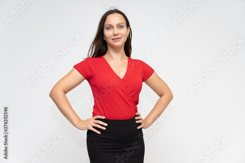 Portrait to the waist of a young pretty brunette woman of 30 years old in a bright red sweater with beautiful dark hair. Standing on a white background, talking, showing hands, with emotions © Вячеслав Чичаев