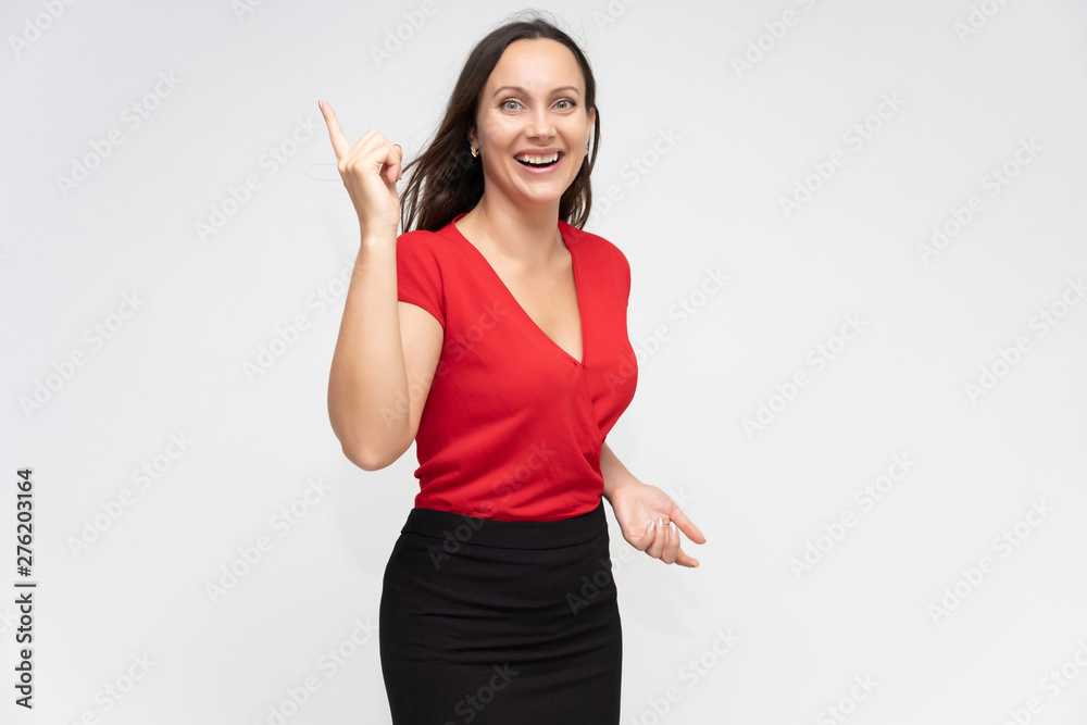 Portrait to the waist of a young pretty brunette woman of 30 years old in a bright red sweater with beautiful dark hair. Standing on a white background, talking, showing hands, with emotions Portrait to the waist of a young pretty brunette woman of 30 years old in a bright red sweater with beautiful dark hair. Standing on a white background, talking, showing hands, with emotions