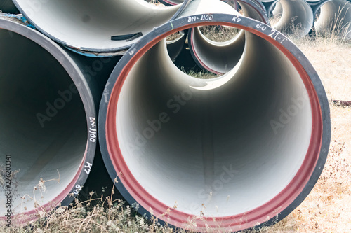 Konstfotografi single ductile iron pipe stored in open space store yard.