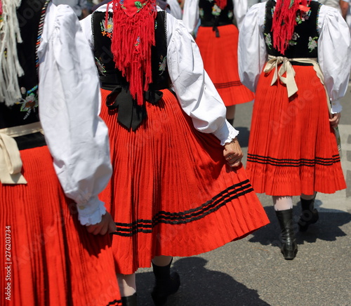 Group of women walk in traditional Polish folk costumess 